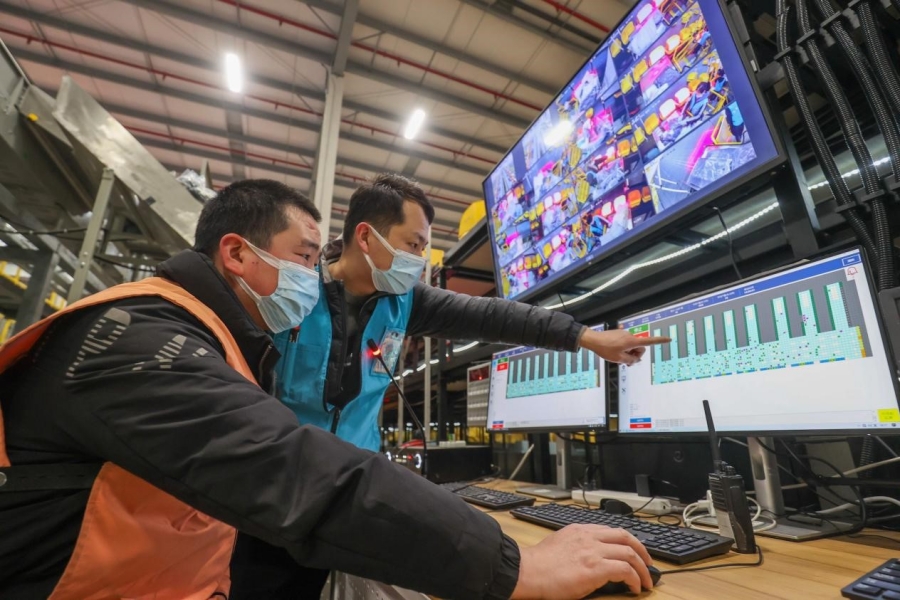 Workers operate robots remotely to sort parcels at the logistics center of Fast Fish, a fast fashion retailer, in a smart logistics park in Deqing county, Huzhou city, east China's Zhejiang province, Jan. 4, 2022. [People's Daily Online/ Wang Shucheng]