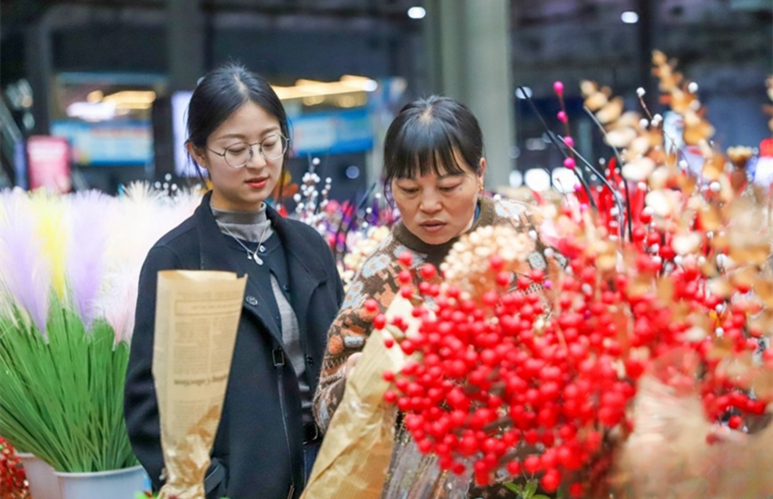 People shop for flowers for Spring Festival in Asia's largest fresh cut flower trading market