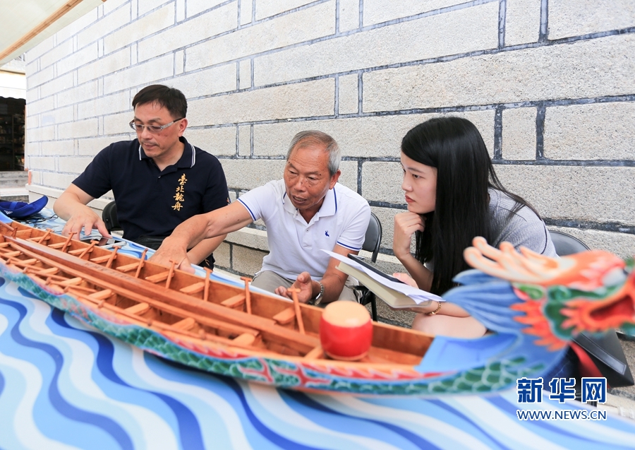 除了赛龙舟，今年主办方首次举办海峡两岸龙舟市集。2日，来自台湾的手工龙舟制作师傅在向游客介绍龙船制作技艺。新华网 肖和勇 摄.jpg