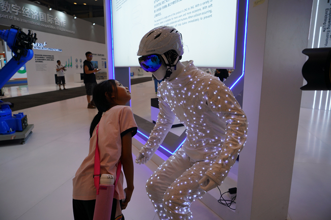 A little girl is attracted by the costume made up of new materials at the 2019 Smart China Expo. (Photo by Gan Xiayi, File Photo)_副本.jpg