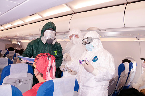 A police officer and medical workers check the body temperature of passengers onboard a flight at Putuoshan Airport in Zhoushan, Zhejiang province, Jan 28, 2020.jpg