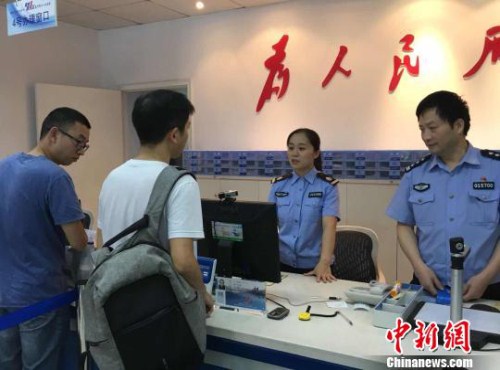 Working staff at a local public security bureau welcomes a Taiwan resident in Hangzhou, Zhejiang province.jpg
