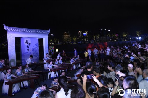 Visitors enjoy the musical performance of guzheng (Chinese zither), a traditional Chinese musical instrument at a cultural exhibition in Hangzhou, Zhejiang province, on Aug 14.jpg