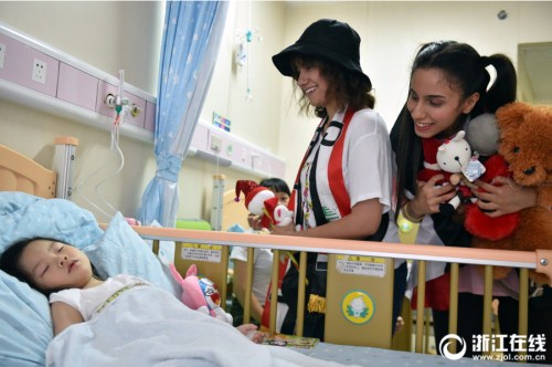 Two Iraqi students from Zhejiang University visit a local children’s hospital with packs of gifts in Hangzhou, Zhejiang province.jpg