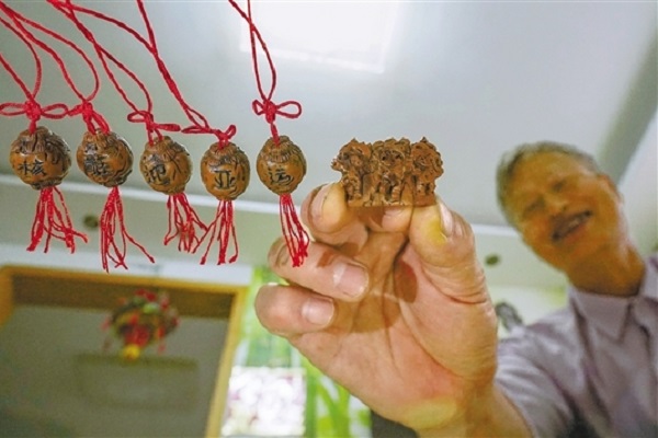Fusion of Culture and Sports | Tongxiang artisan empowers Asian Games via peach pit carving