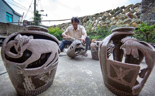 Villager carves animals on vats
