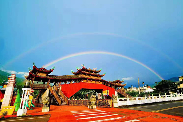 Rainbow over cross-Straits cultural landmark lounge bridge