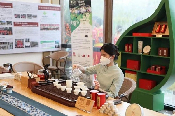 A woman makes red tea for people to try.jpg