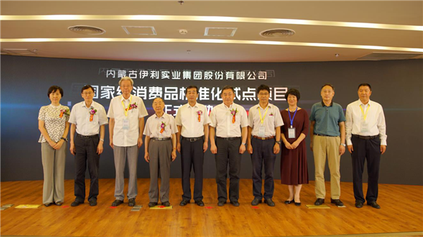 Zhang Jianqiu (fifth from left), CEO of Yili Group poses for a photograph with other attendees at a forum on the standardization of consumer goods held in Beijing, Aug 13.png
