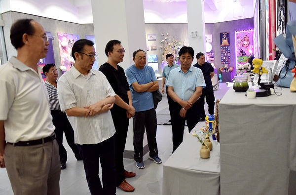 1529917064638083614.jpg Lian Ji (second from left) admires IMNU graduate works at the International Modern Design Art College on June 21..jpg