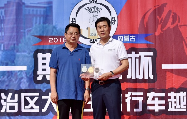 Zhang Haifeng (L), IMNU vice-president, presents commemorative medals to a representative of the sponsor company on June 21.jpg