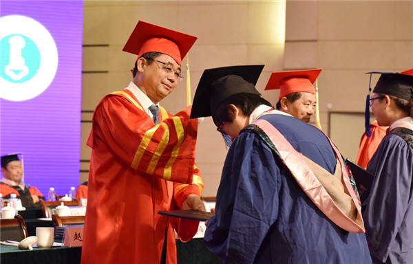 Graduates receive diplomas from the president and vice-president of IMNU during the ceremony, July 3..jpg