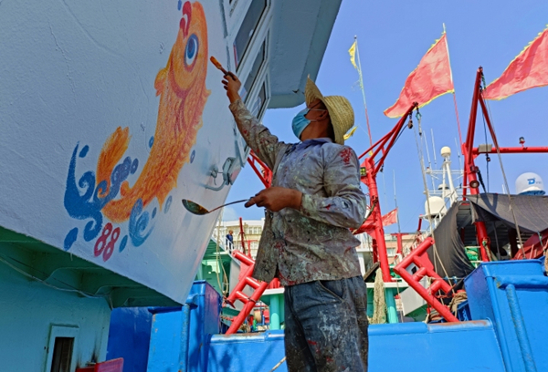 Fishermen paint patterns on boats to pray for bountiful harvest