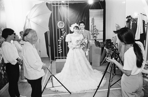 1980s《乡间影楼》80年代，青年人结婚是拍一套婚纱照片，也在农村时尚起来。图为无锡一家小影楼拍摄婚纱照时喜气洋洋的情景。作者：王广林.jpg
