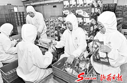 The staff of Pingyao beef Group Corporation, one of China’s time-honored brands, package and inspect products n March 31.(Photo/Shanxi Daily)