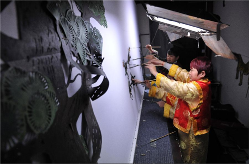 “Pocket people” present The Crane and the Turtle shadow puppet in a Pingyao theater, on April 14. (Photo/Xinhua)
