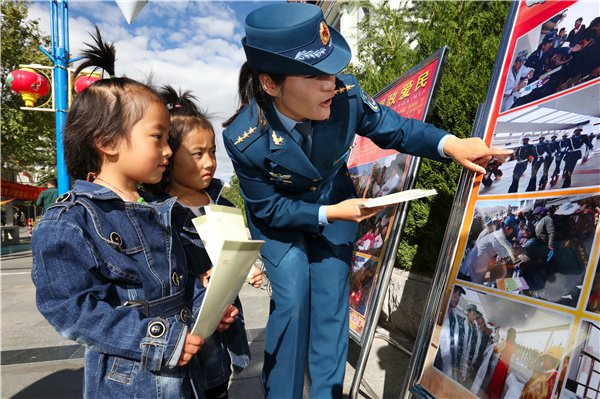 国防教育日，在拉萨街头开展宣传教育活动，索朗给藏族儿童讲解相关教育展板。.jpg