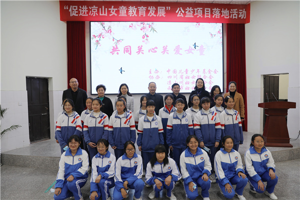 Attendees pose for a group photo at the launch ceremony of a public welfare project aimed to assist girls in Liangshan Yi Autonomous Prefecture in Southwest China's Sichuan Province.jpg