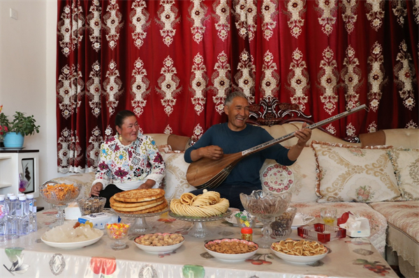 A farmer performs using dotar, a traditional Uygur instrument, in Jinnan New Village of Qira county, Hotan. [Photo by Wang Zhuangfei chinadaily.com.cn].jpg