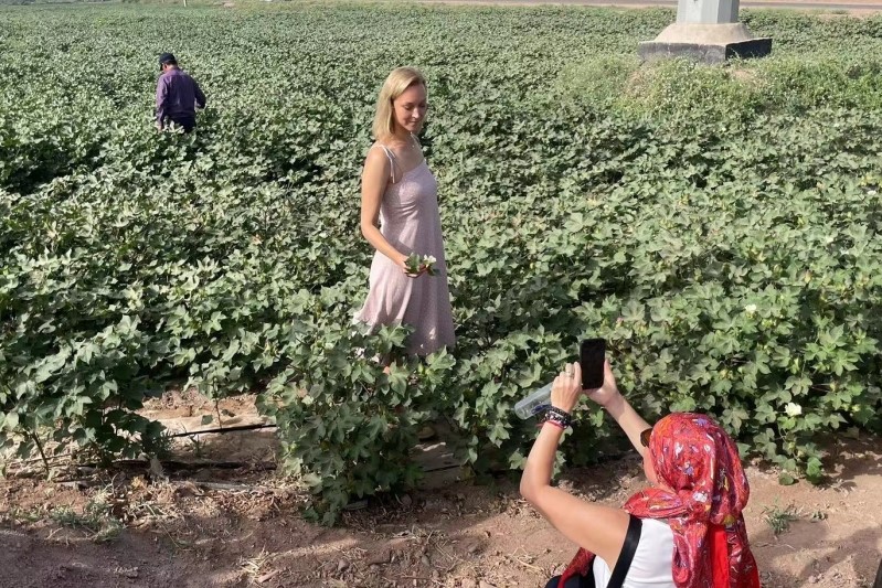 俄罗斯媒体代表团成员在棉田里拍照。.jpeg