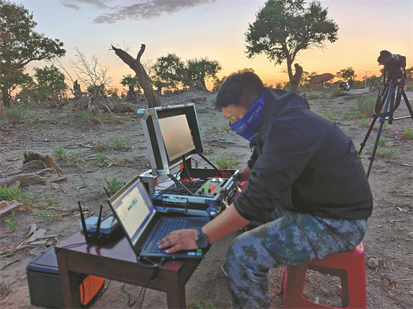 An engineer tests equipment before a livestreaming session of the meteor shower at the Poplar Forest Scenic Area in Yiwu county on Aug 14..jpg