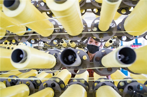 An employee checks production machinery at a factory in Hefei, Anhui province, on Monday after some companies resumed production.jpg