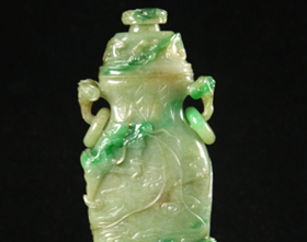 A jade vase with a lid and patterns of a dragon educating its son