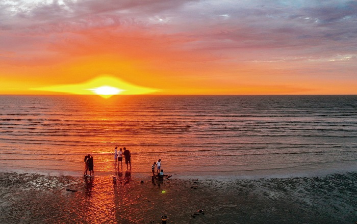 1 7月7日晨，南通启东黑沙滩，游客们在沙滩游玩，一轮新日跃出海面，光照万物。黄是春 摄.jpg