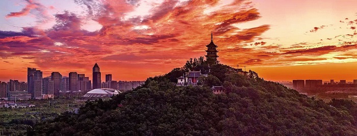 2 7月3日清晨，通城上空被漫天橙红朝霞铺满，云彩如火焰般绚烂渐变，为五山与城市披上梦幻光晕。 彭常青 摄.jpg