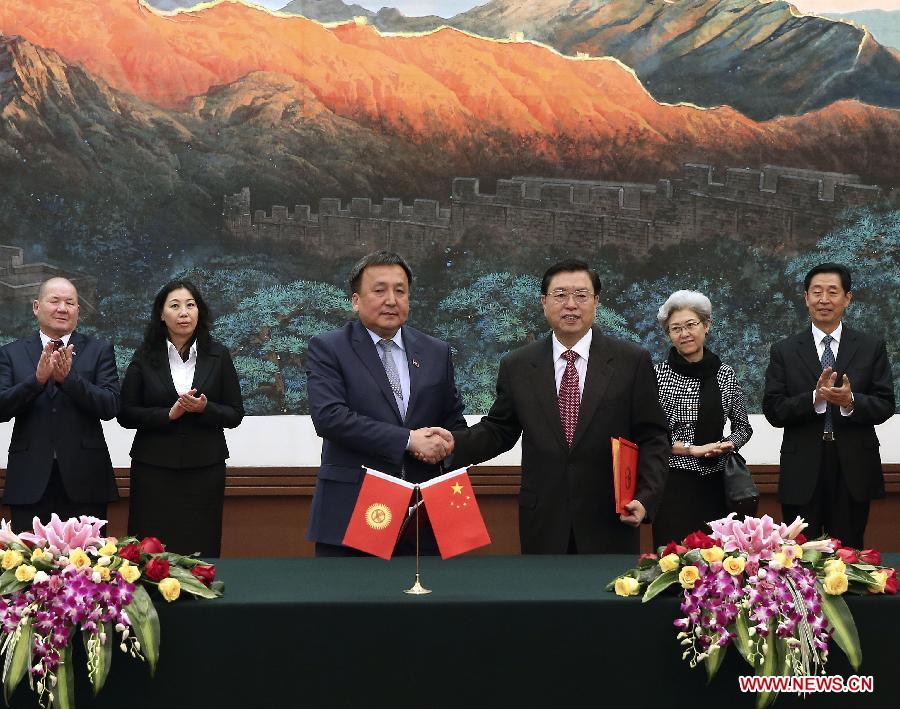 Zhang Dejiang (3rd R), chairman of China's National People's Congress (NPC) Standing Committee and Kyrgyz Parliament Speaker Asylbek Zheenbekov (3rd L) sign a memorandum of cooperation after they held talks in Beijing, capital of China, May 6, 2014. (Xinhua/Pang Xinglei) 